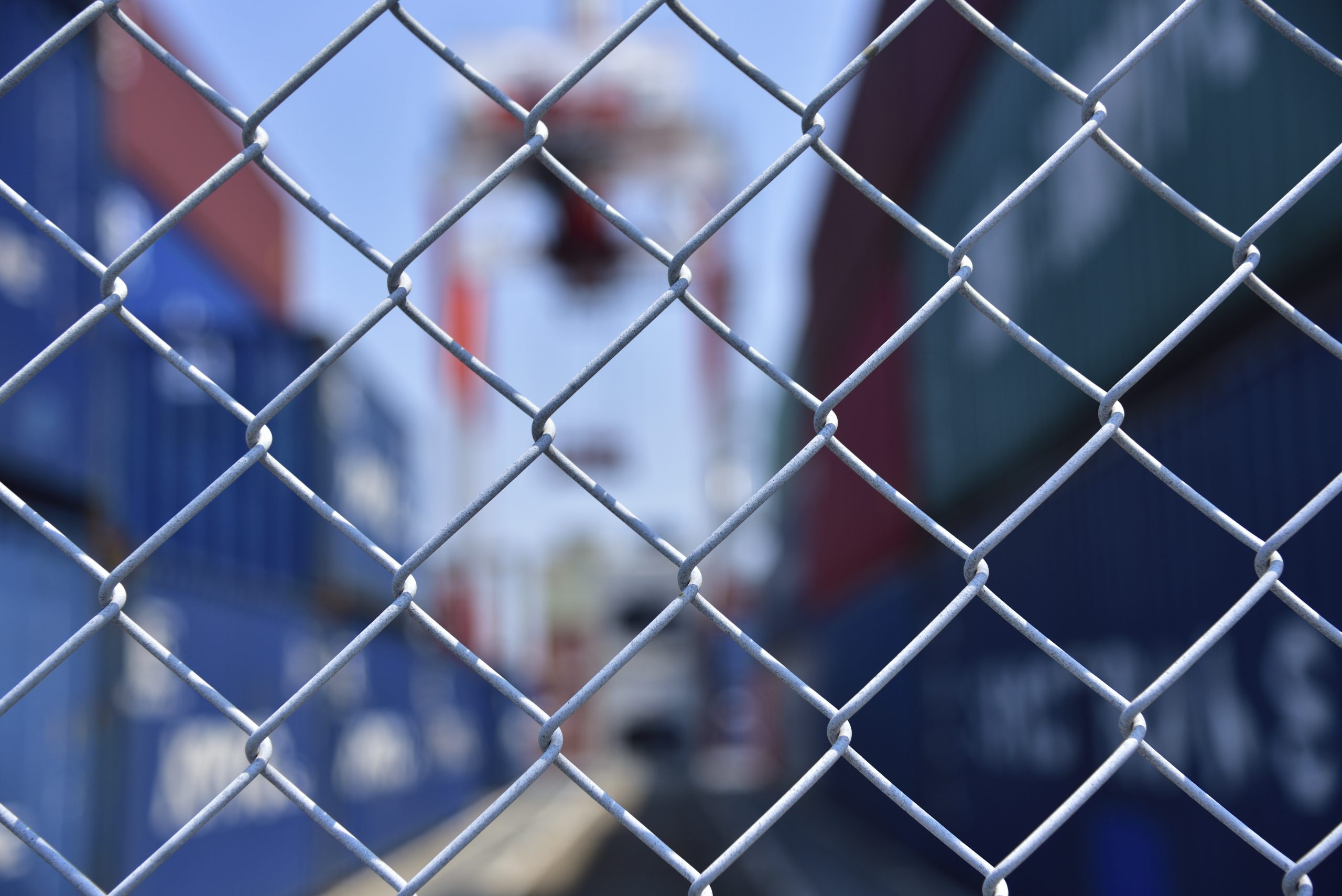 Wire mesh fence enclosing the maritime transport terminal: shipping industry